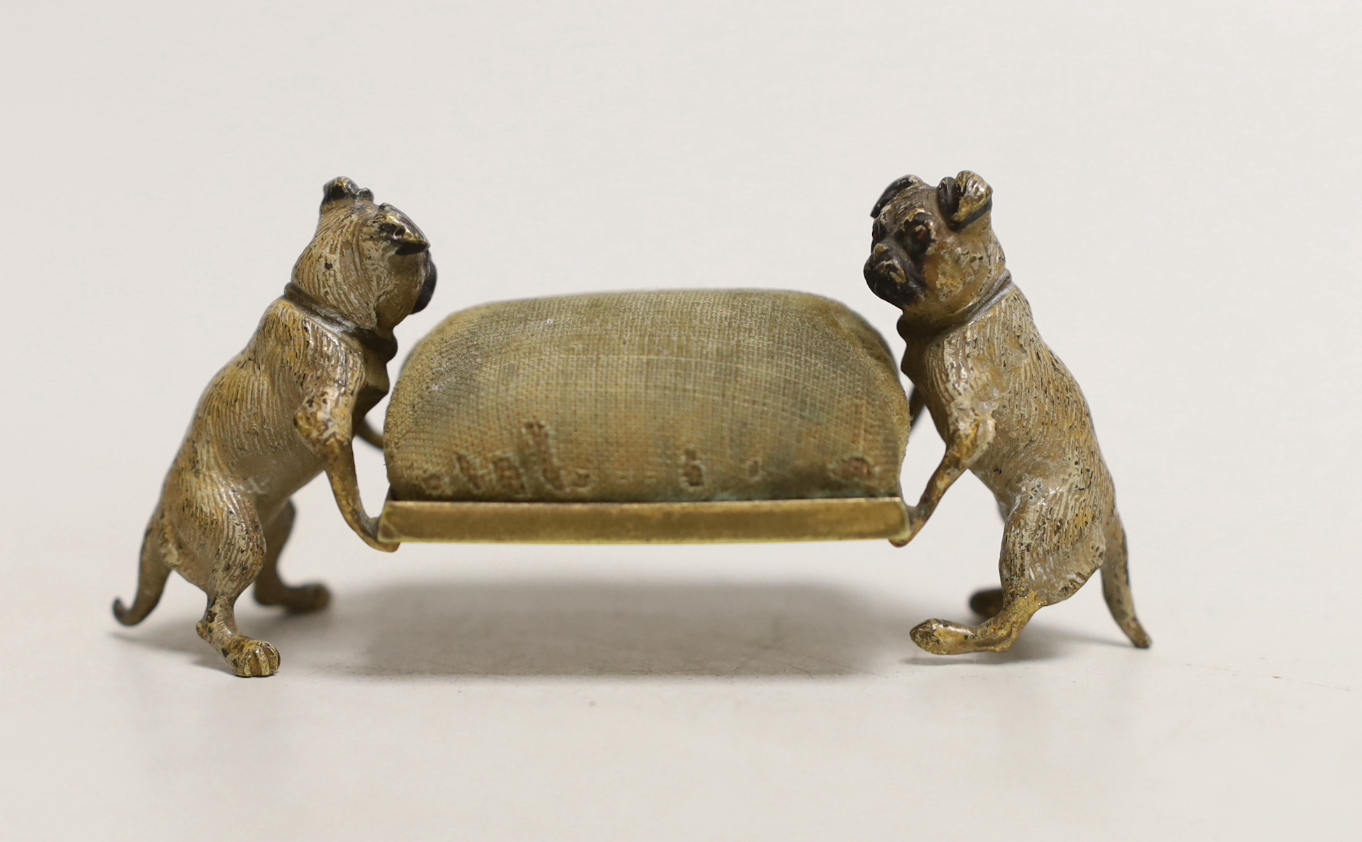 An early 20th century Austrian cold painted bronze ‘pug dogs’ pin cushion, 9cm long